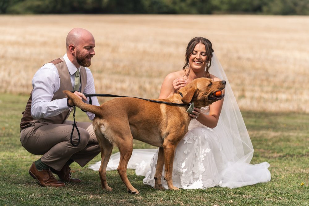 Liam with his wife and their dog in a field